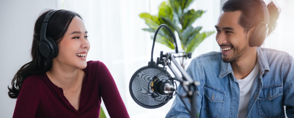 two Asian hosts radio recording podcast in broadcasting studio